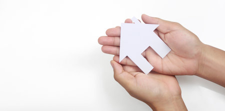 Hands holding paper house, family home and protecting insurance conceptの写真素材