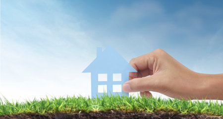 Hands holding paper house, family home and protecting insurance conceptの写真素材