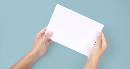 Hands holding paper blank for a letter paper