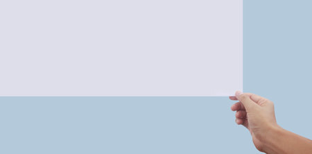 Empty space for text. Hand is holding the white blank paperの写真素材
