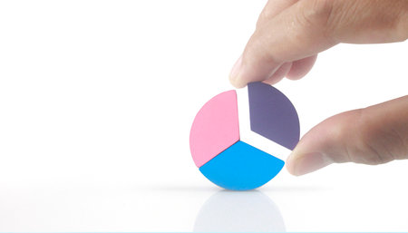 Business connecting piece of multi colored pie wood chart in a hand