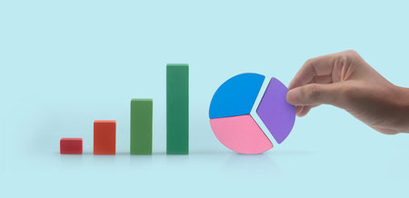 Business connecting piece of multi colored pie  chart in a hand