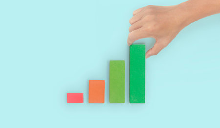 Business connecting piece of multi wood chart blocks steps in a hand
