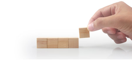 Hand putting wooden cube blocks, and action planの写真素材