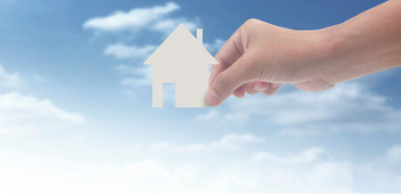 Hands holding paper house, family home and protecting insurance conceptの写真素材
