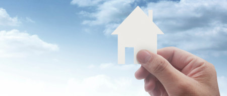 Hands holding paper house, family home and protecting insurance conceptの写真素材