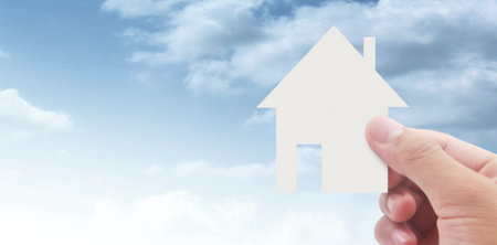 Hands holding paper house, family home and protecting insurance conceptの写真素材