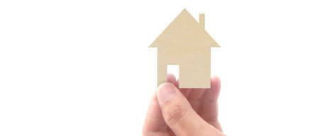 Hands holding paper house, family home and protecting insurance conceptの写真素材