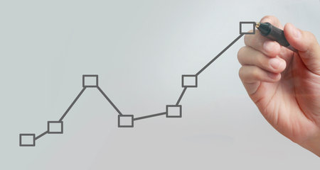 Male hand drawing graph chart showing business profit growth increasing to futureの写真素材