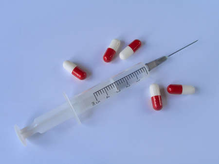 Syringe and pills, blue background