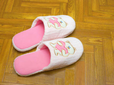 Childlike slippers on parquet, bear with の写真素材