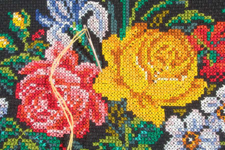 Roses and needle with thread - embroidery (closeup)の写真素材