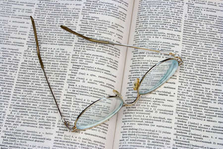Glasses on opened book (dictionary)