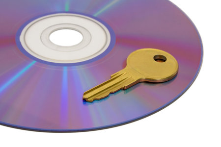 Key on computer cd, isolated on white backgroundの写真素材