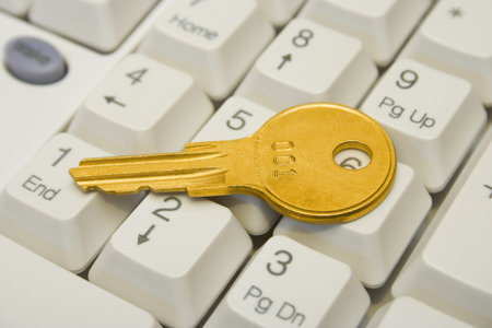 Golden key on computer keyboard, close-up