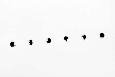 Holes on paper, isolated on white backgroundの写真素材