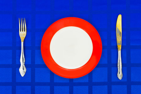 Plate, knife and fork on table cloth, food backgroundの写真素材