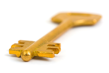Macro of retro gold key isolated on white backgroundの写真素材