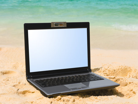 Computer notebook on beach - business travel backgroundの写真素材