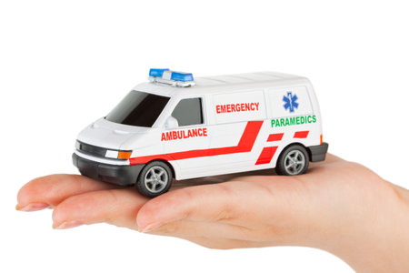 Hand with toy ambulance car isolated on white backgroundの写真素材