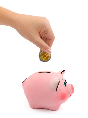 Piggy bank and hand with coin isolated on white backgroundの写真素材