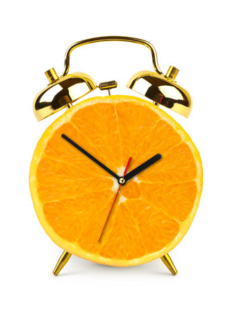 Clock made of orange fruit isolated on white background