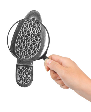 Magnifying glass in hand and shoe printout isolated on white backgroundの写真素材