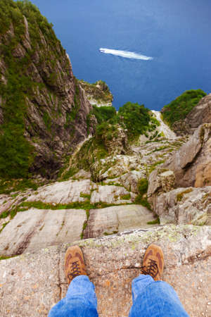 Man standing on cliff Preikestolen in fjord Lysefjord - Norway - nature and travel background