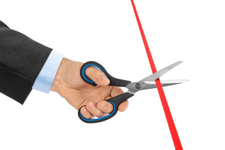 Scissors in hand and ribbon isolated on white backgroundの写真素材