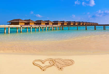 Drawing connected hearts on beach - concept holiday backgroundのeditorial素材