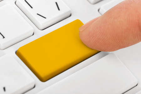 Computer notebook keyboard with blank yellow key - technology backgroundの写真素材