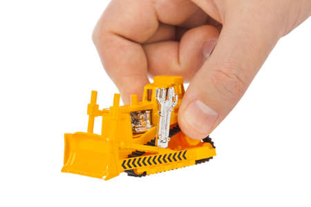 Hand with toy bulldozer isolated on white backgroundの写真素材