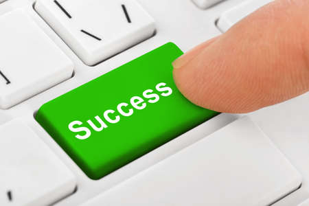 Computer notebook keyboard with Success key - technology background