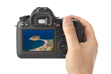 Hand with camera and Island Sveti Stefan - Montenegro image (my photo) isolated on white backgroundのeditorial素材