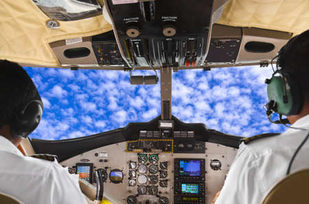 Pilots in the plane cockpit and cloudy sky - transportation backgroundの写真素材