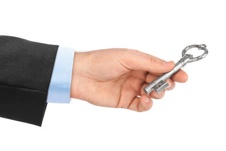 Hand with retro silver key isolated on white background
