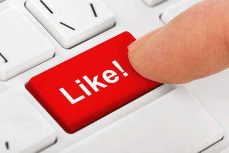 Computer notebook keyboard with Like key - technology backgroundの写真素材