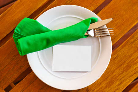 Dishware and blank paper card on table in restaurant - food backgroundの写真素材