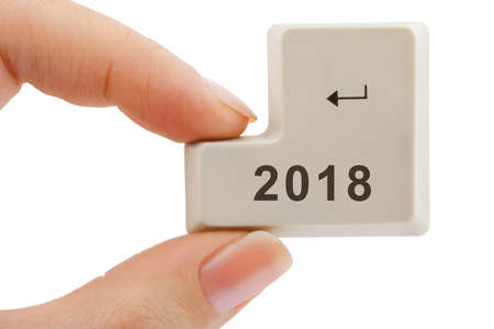 Computer button 2018 in hand isolated on white background