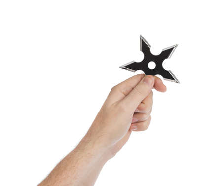 Hand is throwing ninja shuriken isolated on white backgroundの写真素材