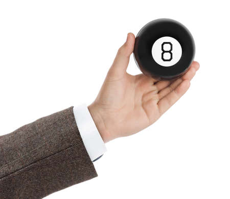 Hand with magic billiard ball number eight isolated on white backgroundの写真素材