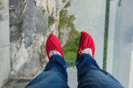Tourist in shoe covers on glass pathway in Tianmenshan nature park - China - travel backgroundの写真素材