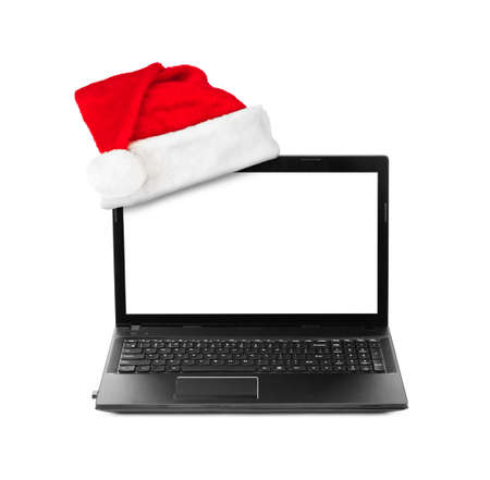 Notebook computer and Santa Claus red christmas hat isolated on white backgroundの写真素材