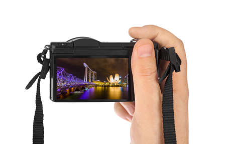 Hand with camera and Singapore city skyline (my photo) isolated on white background