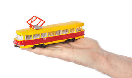 Hand with toy tram isolated on white backgroundの写真素材