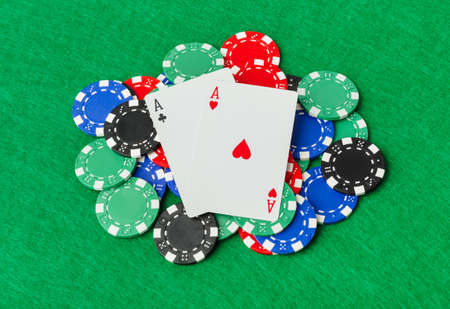 Casino chips and playing cards on green table - gambling background