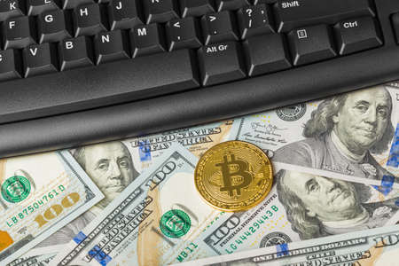 Computer and bitcoins on money - business technology background