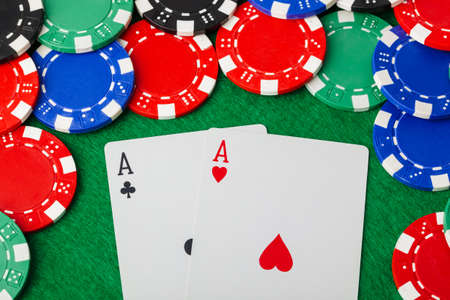 Casino chips and playing cards on green table - gambling background