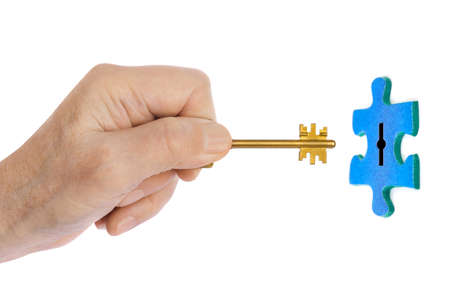 Hand with key and puzzle isolated on white background