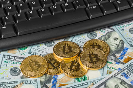Computer and bitcoins on money - business technology background